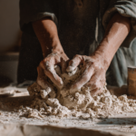 Hands kneading clay in workshop