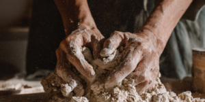 Hands kneading clay in workshop